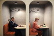 © Seventyfour - Graphic side view portrait of two business people working in separate booths at co-working space, copy space