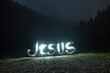 © Denis Rozhnovsky - The inscription Jesus made on a long exposure at night on the road among the forest.