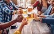© Davide Angelini - Top view of friends cheering with home brew in pub bar restaurant. Young people hands toasting and beers half pint.