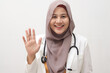© airdone - Beautiful young Asian muslim female doctor woman using stethoscope. Waving saying hello happy and smiling, friendly welcome gesture