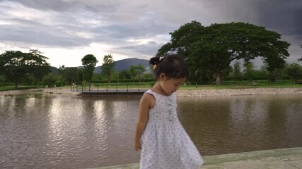 Wall Mural -  little girl standing at pond outdoor