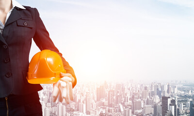 Woman architect holding safety helmet