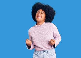 Sticker - Young african american girl wearing casual clothes very happy and excited doing winner gesture with arms raised, smiling and screaming for success. celebration concept.