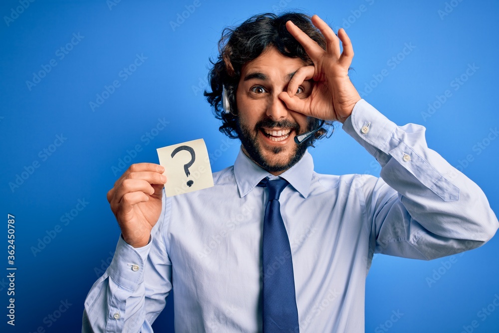 Young call center agent man with beard working using headset holding ...