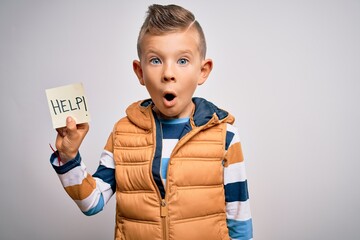 Young little caucasian kid asking for help on a paper note as violence victim message scared in shock with a surprise face, afraid and excited with fear expression