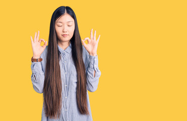 Sticker - Young beautiful chinese woman wearing casual shirt relax and smiling with eyes closed doing meditation gesture with fingers. yoga concept.