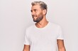 © Krakenimages.com - Young handsome blond man wearing casual t-shirt standing over isolated white background looking to side, relax profile pose with natural face and confident smile.