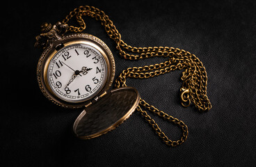 Wall Mural - Vintage pocket watch on black leather background.