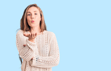 Poster - Young beautiful blonde woman wearing casual sweater looking at the camera blowing a kiss with hand on air being lovely and sexy. love expression.