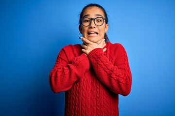 Poster - Young beautiful asian woman wearing casual sweater and glasses over blue background shouting and suffocate because painful strangle. Health problem. Asphyxiate and suicide concept.