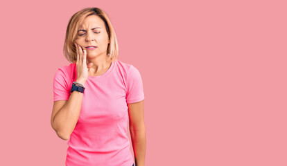 Wall Mural - Young blonde woman wearing sportswear touching mouth with hand with painful expression because of toothache or dental illness on teeth. dentist