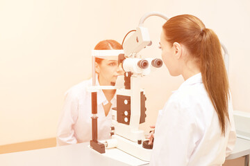 Wall Mural - ophthalmologist doctor in exam optician laboratory with female patient. Eye care medical diagnostic. Eyelid treatment