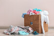 © Pixel-Shot - Basket with dirty clothes near light wall