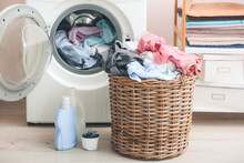 Washing Machine And Basket With Dirty Clothes In Home Laundry Room