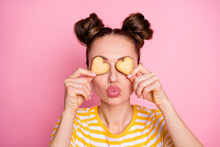 Closeup Photo Of Attractive Lady Two Funny Buns Flirty Hiding Eyes By Cookies Hearts Sending Air Kisses Wear Casual Yellow Striped Shirt Isolated Pink Color Background