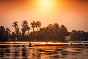 Wall Mural - An unidentified man sails his canoe in backwaters in an afternoo