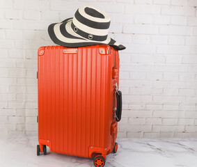 Red Suitcase with hat  in wall background which  traveler  travel concept