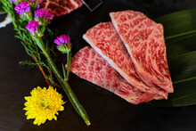 Slice Japanese Beef Neck Chuck Or Jyu Rosu Wagyu Serving On Black Plate And Decorate With Flower. Preparation For BBQ.