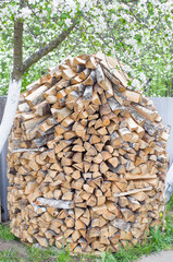 Stack of chopped firewood in the country, background