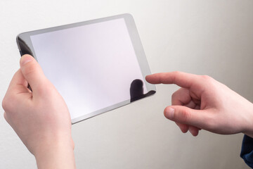 Poster - Tablet in hands of man. Electronic tablet and hands close-up. Man holds off gadget. Concept - electronic reader of books. Device for reading electronic books. Reading tablet on a gray background.