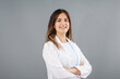 Beautiful Turkish woman doctor with warm and confident smiling in a grey background studio with copy space