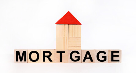 Wooden cube with the inscription mortgage and house on a white background.Photos for real estate business.The concept of buying a home with a mortgage.