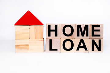 LOAN HOME WRITING ON WOODEN CUBES near a wooden model of a house on a white background. Business, investment, crisis, recession, developer, real estate and real estate concept