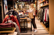 © BGStock72 - Young woman shopping and searching among clothes at clothes store