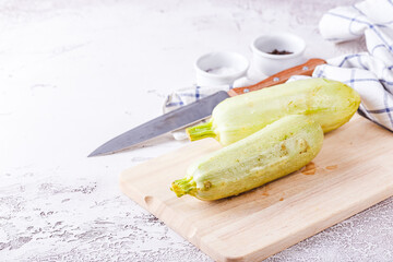 Sticker - Fresh zucchini on a wooden board with a knife