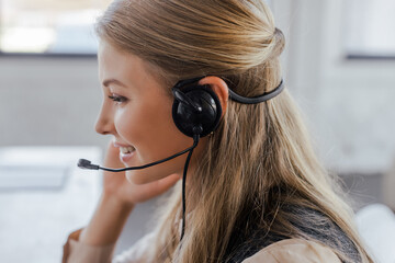 Poster - side view of cheerful operator in headset smiling in office