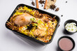 Restaurant style Chicken Tikka Biryani packed for home delivery in plastic box or container with Raita and salan