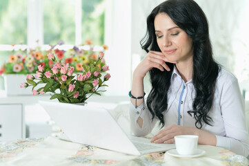 Close up portrait of beautiful young woman using modern laptop