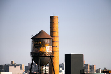 A rooftop water tower shines brightly in Brooklyn afternoon sun