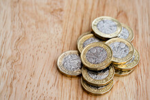 Closeup Of The New British One Pound Coins, Selective Focus Of One Pound British Sterling Coins On Wooden Table.