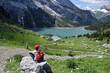 Young hiker contemplating the beautiful landscape around the Oeschinen Lake in the Bernese Oberland, Switzerland
