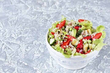 Wall Mural - Salad with strawberries, quinoa, avocado, cucumber, lettuce, onions and green peas. vegetarian food.copy space