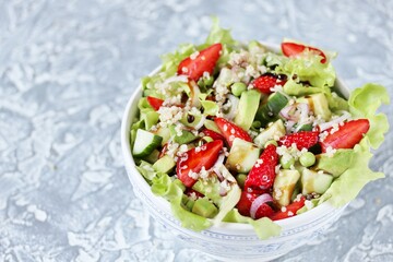 Wall Mural - Salad with strawberries, quinoa, avocado, cucumber, lettuce, onions and green peas. vegetarian food.copy space