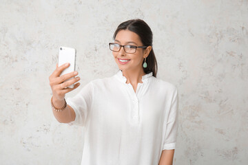 Sticker - Beautiful young woman with mobile phone on light background