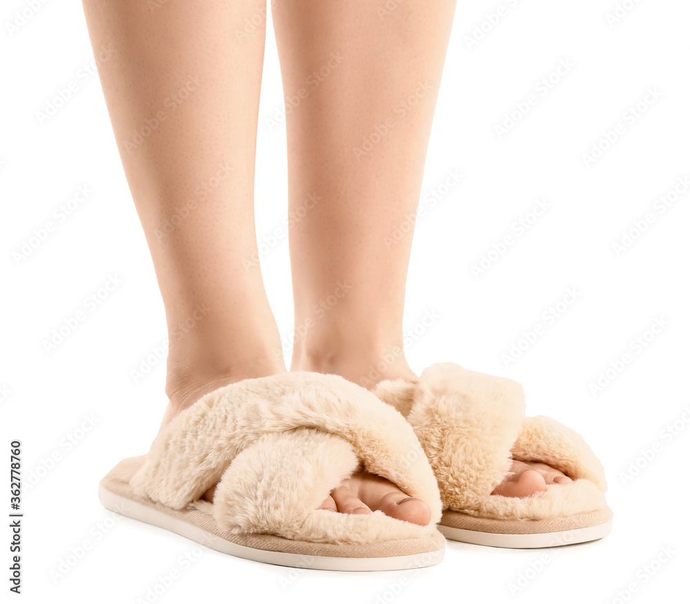 Female legs in soft slippers on white background