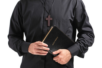 Handsome young priest with Bible on white background, closeup