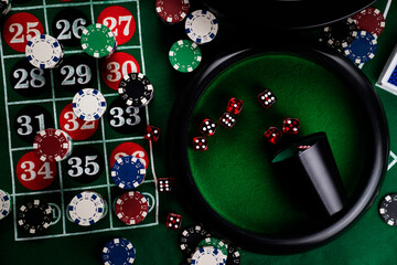 Roulette table in casino. Casino felt green table with red and black numbers. Stack of poker chips.