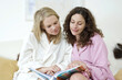 © ImageHit - Two women in bathrobes looking through a photo album