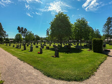 Old Swedish Cemetery With Green Trees And Blue Sky With Puffy White Clouds On A Clear Summer Day