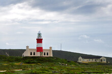 Landscape With The Lighthouse On The Beautiful Rocky Cliff On The Windy Day At Cape Agulhas, The Most Southern Point Of Africa, Where The Indian And Atlantic Oceans Meet, South Africa