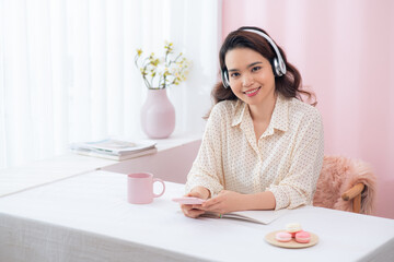 Fototapete - Young asian casual businesswoman listening music