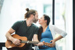 © chokniti - Husband plays guitar for pregnant wife at home