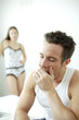 © ImageHit - Man yawning with woman standing in the background