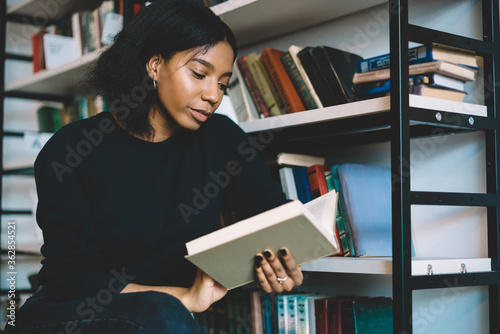 Cuadros en Lienzo Serious female dark skinned student concentrate on reading book in college libra