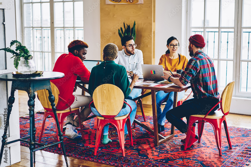 Multiracial male and female colleagues discussing ideas and opinions at ...
