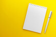 Blank notepad and pen on trendy dark yellow background. Notebook for ideas message, list and inspiration. Top view, flat lay with copy space. Mockup for your design.